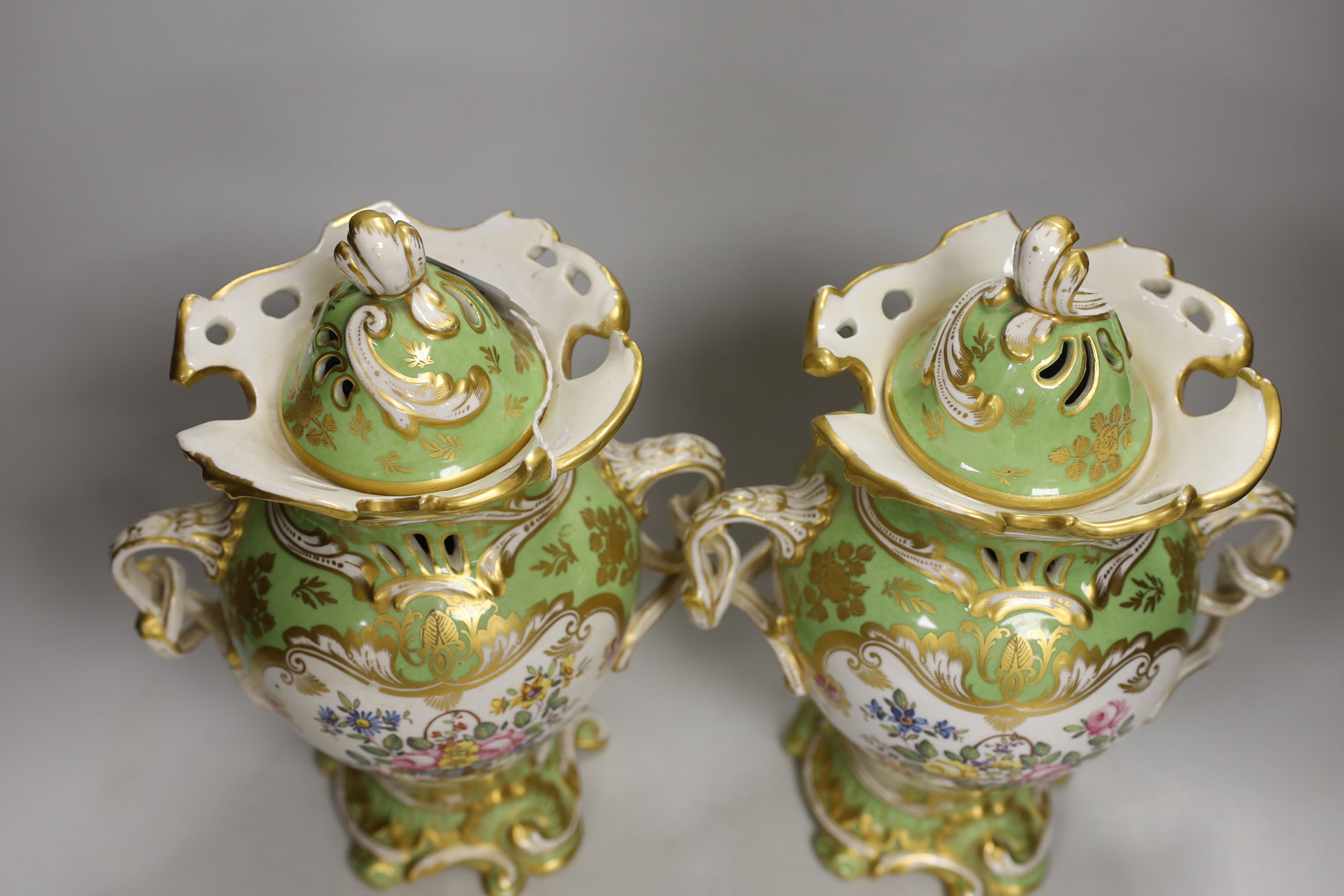 A pair of Rockingham style porcelain pot pourri vases, each of rococo form painted to each side with baskets of flowers, rare brown printed Rockingham griffin mark, 29cm high